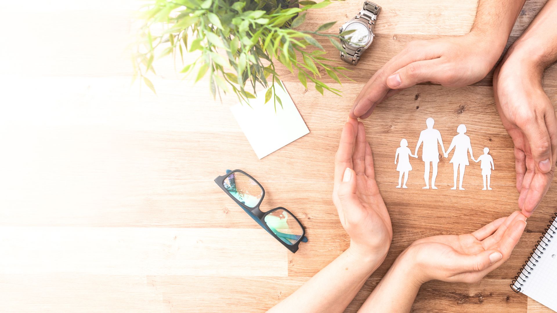 Two sets of hands joined in a circle around an image of a family holding hands.