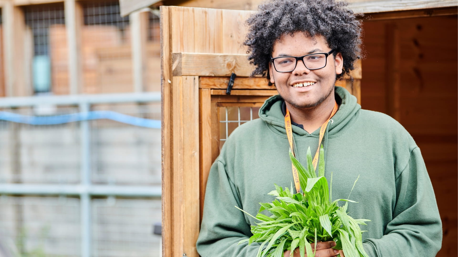 Student smiling while holding potted plant