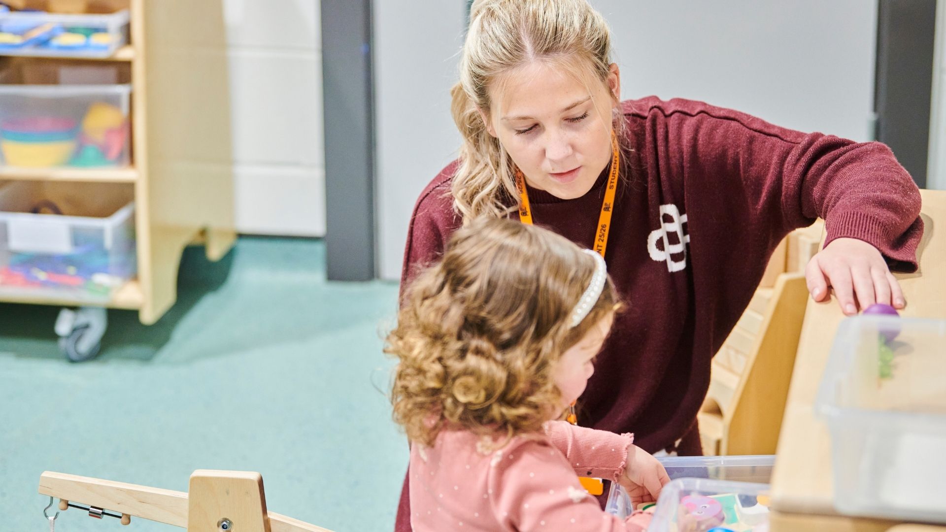 Childcare student playing with small child