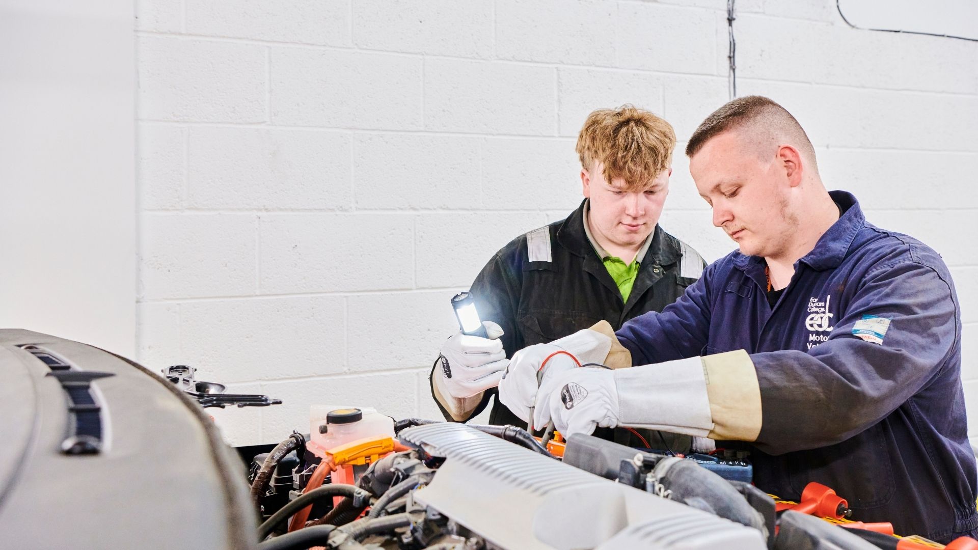 Young man working on the underneath of a car.