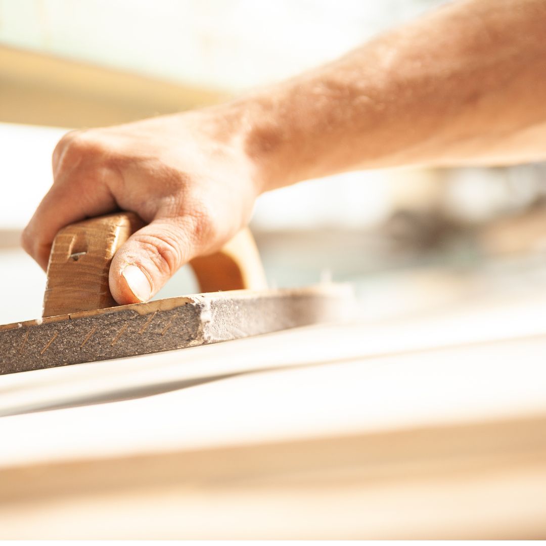 Wood being sanded down using tool.