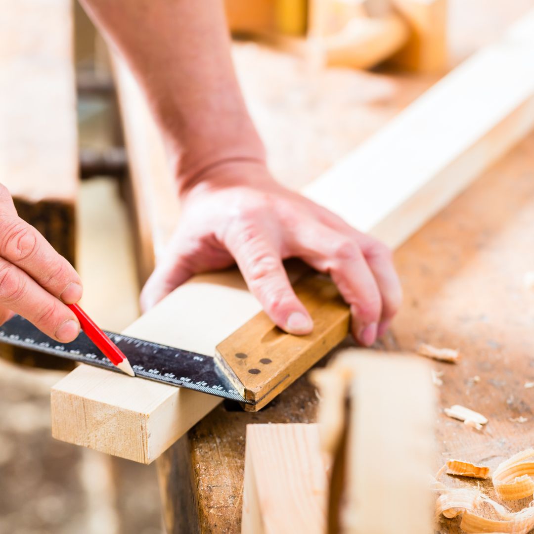 Person using a electric saw to cut wood.