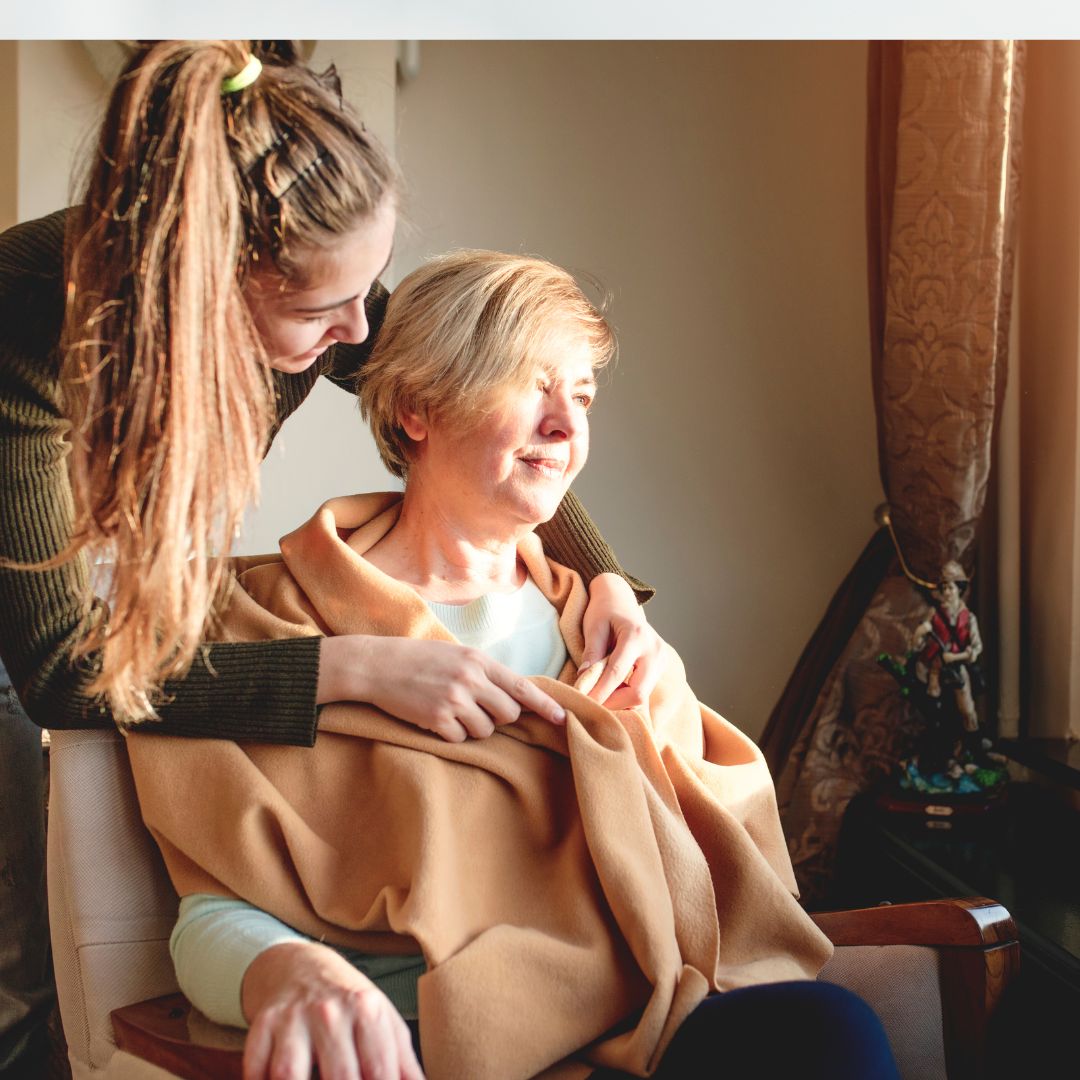 Young woman fastening cardigan of older person