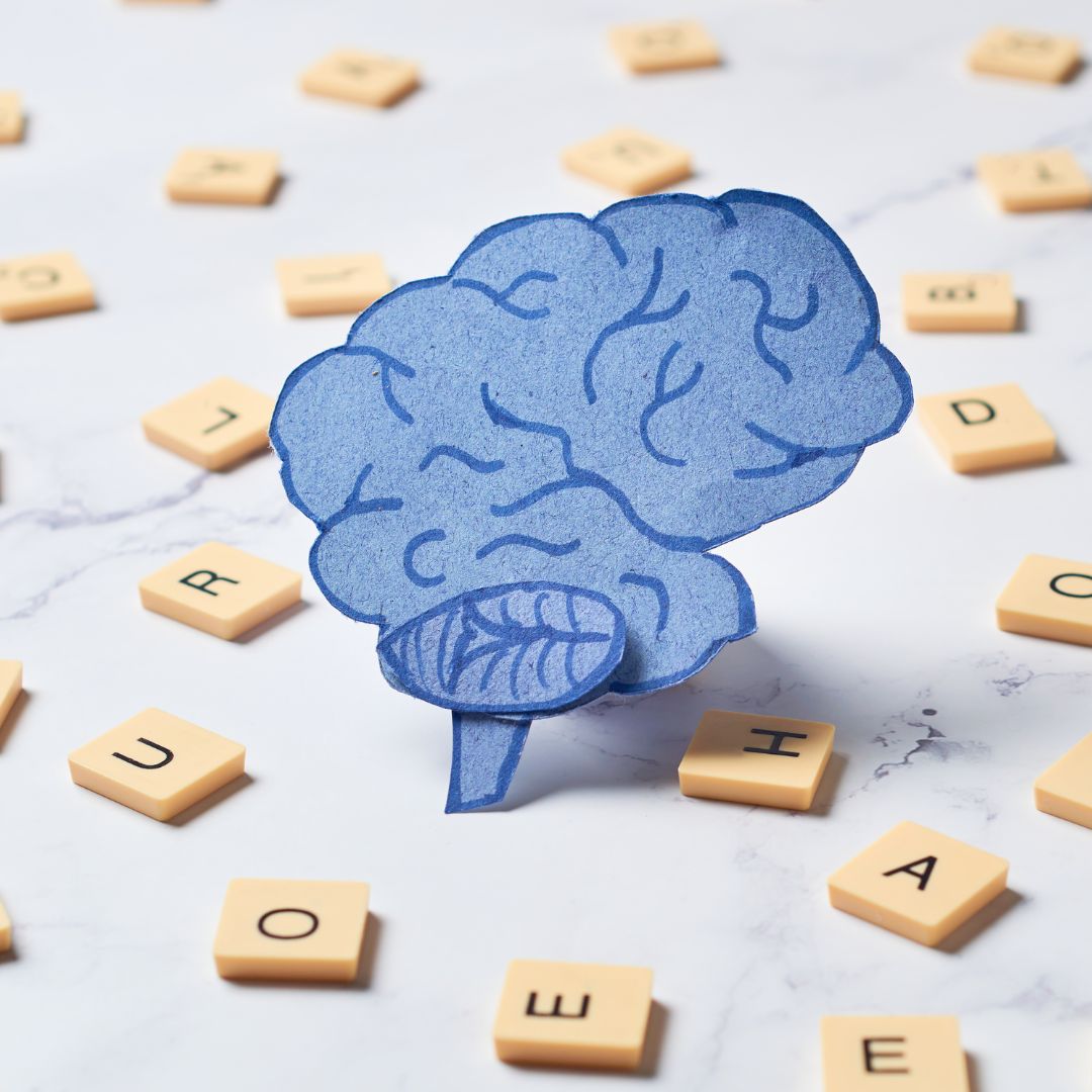 Blue brain graphic surrounded by wooden tiles showing letters