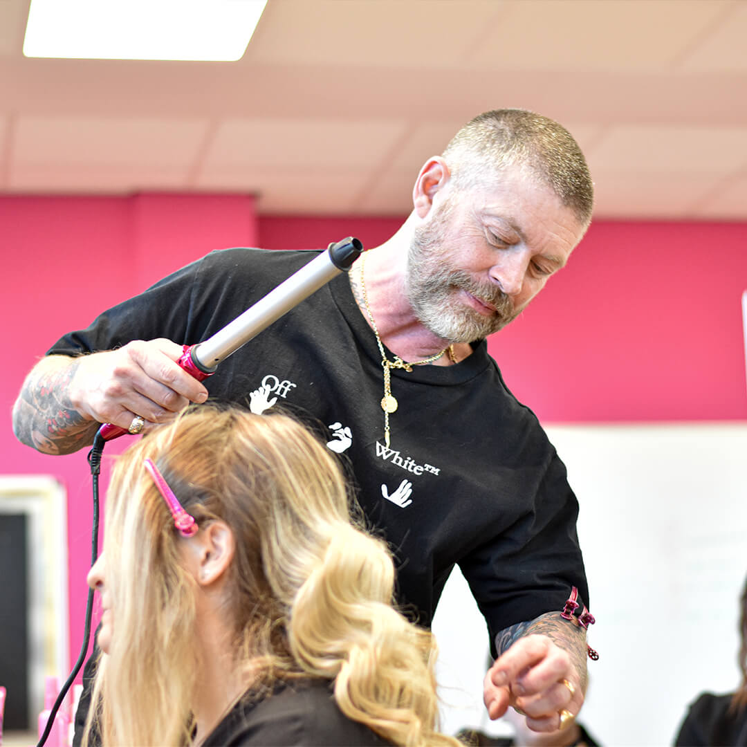 Lee Stafford styling a female students hair.