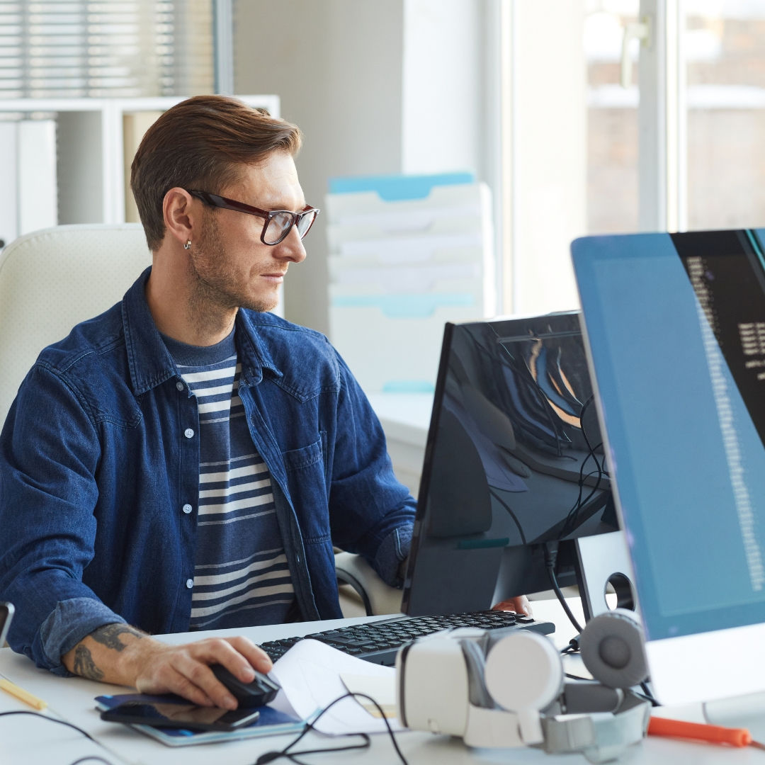 Man sat at desk on a PC.