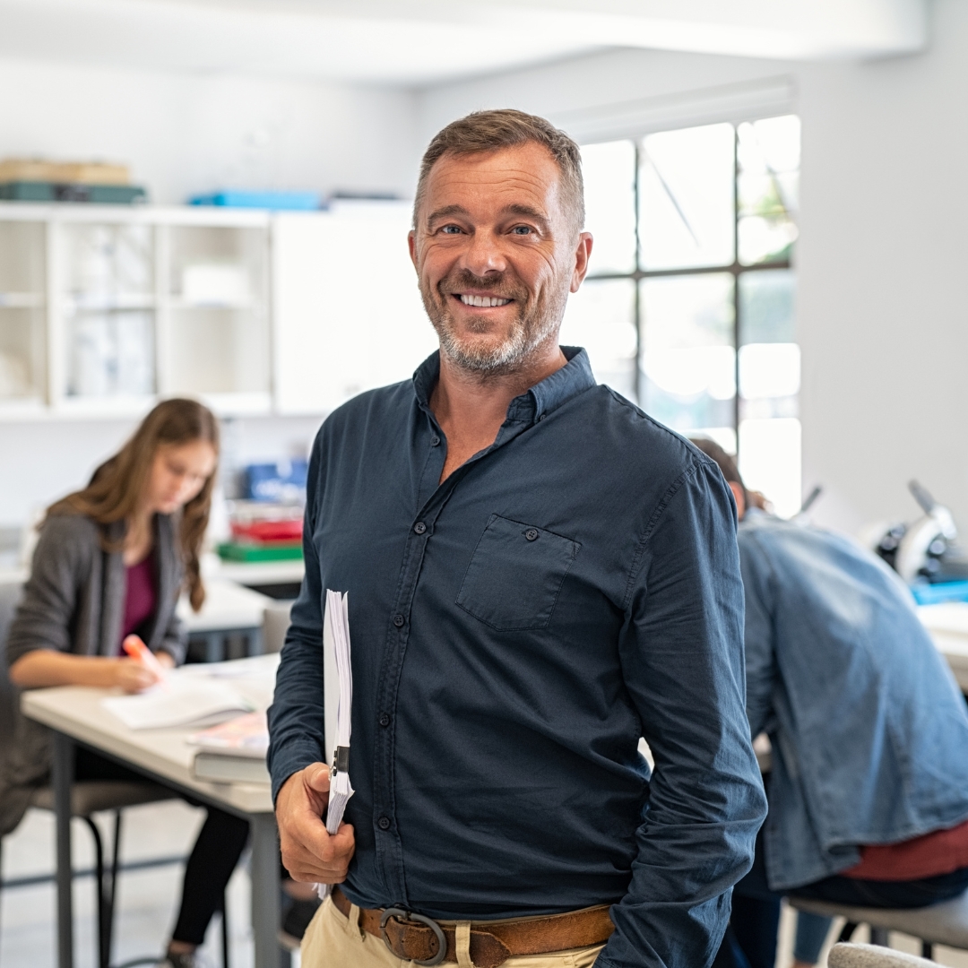 Teacher smiling in front of class.