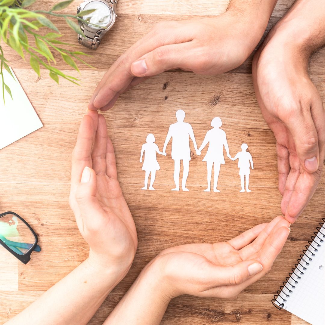 Two sets of hands joined in a circle around an image of a family holding hands.