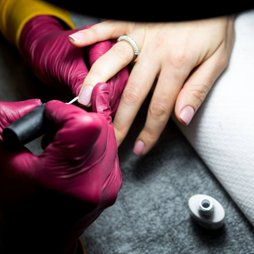 A young woman painting someones nails.