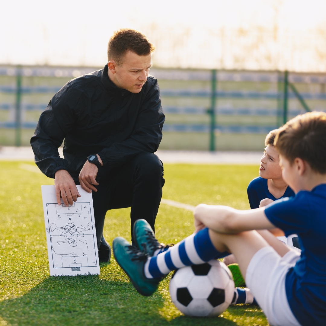 Coach giving advice to kids.