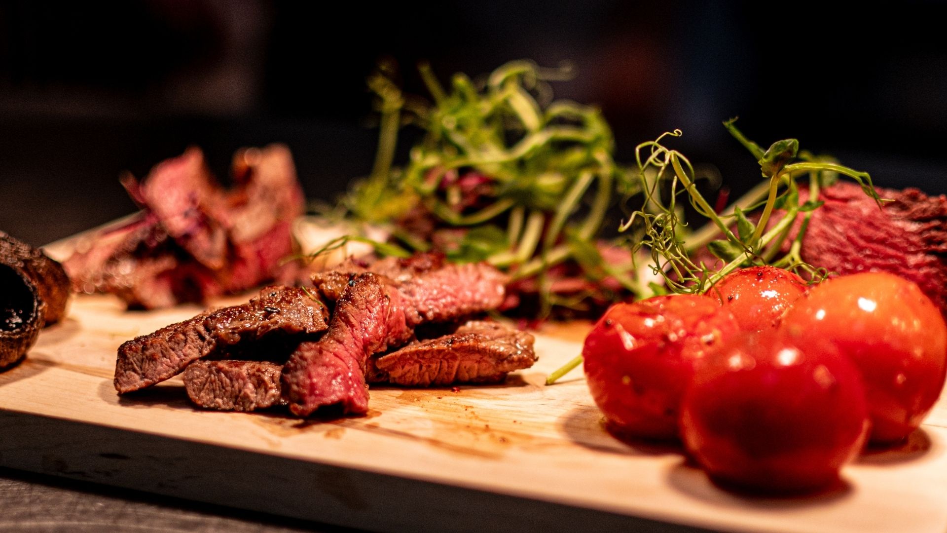 Steak and tomatoes on a wooden board