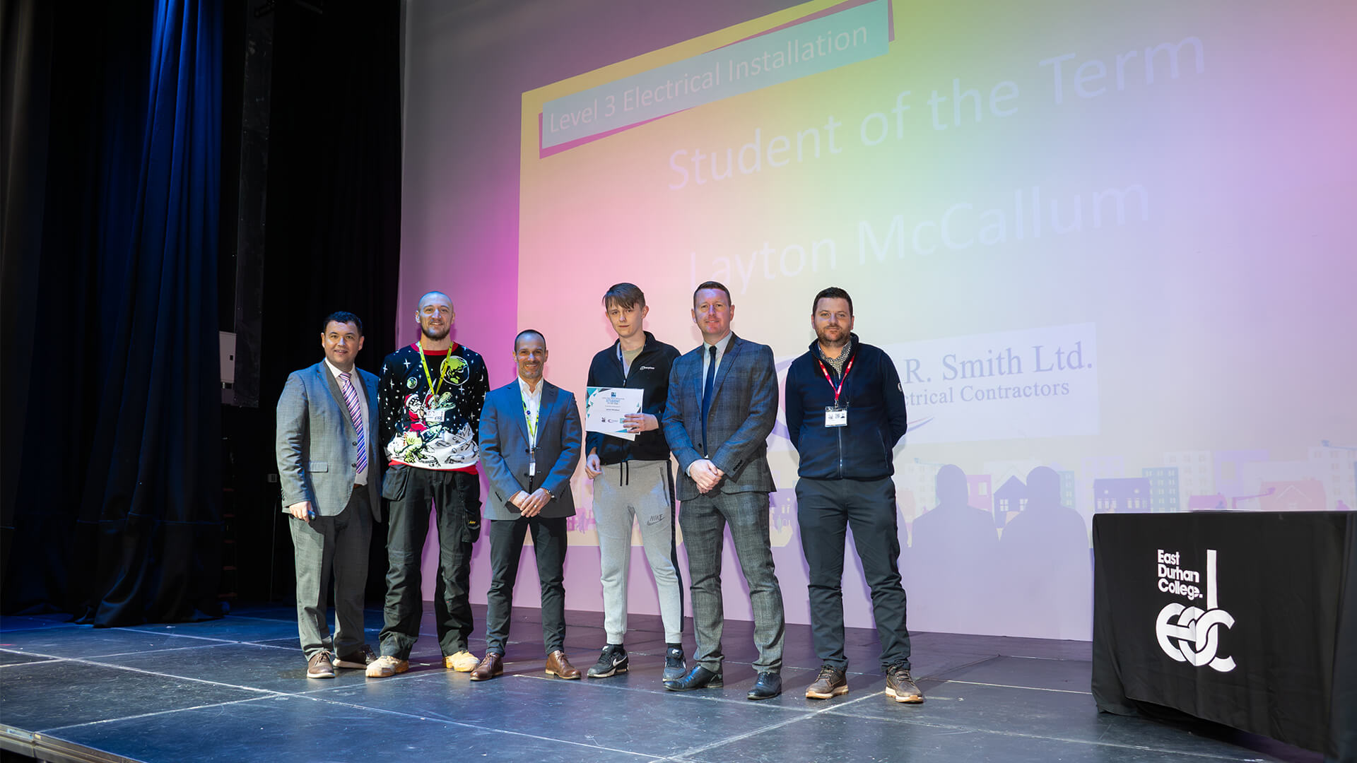 Group of men standing smiling at the camera holding awards certificate