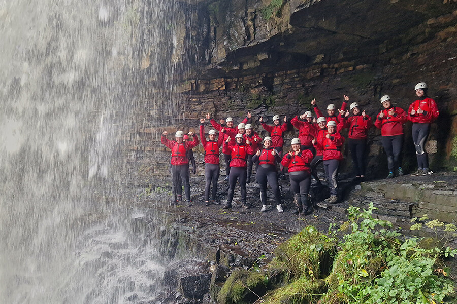 King's Trust Learners celebrate stood next to waterfall