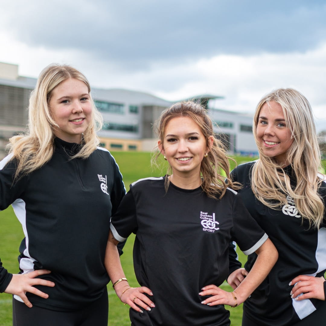 Three sports students smiling at camera