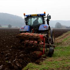 A tractor ploughing a muddy field