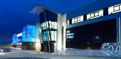 Exterior of East Durham College's Peterlee campus building lit up at night 
