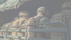 The back of four soldiers sat in a vehicle
