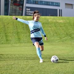 A female footballer about to kick a ball