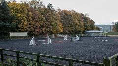 The menage outdoor equine arena, with jumps set up, at East Durham College's Houghall Campus