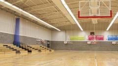 Interior of the East Durham College sports hall, with bleachers and basketball hoops