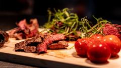 Steak and tomatoes on a wooden board