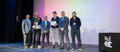Group of men standing smiling at the camera holding awards certificate