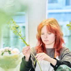 Floristry student stripping flower