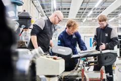 Three engineers standing around a machine